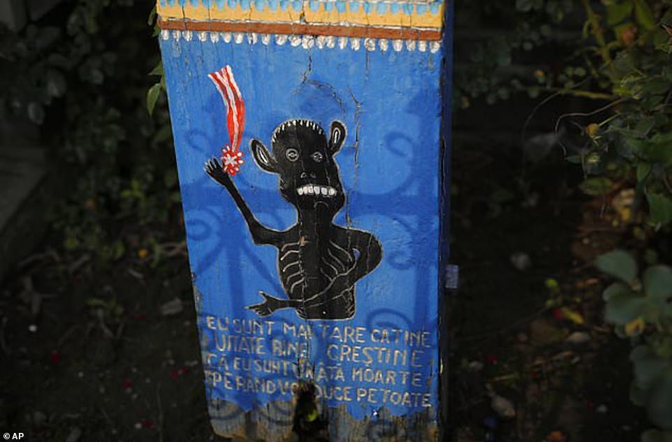 Une croix à l'entrée porte une représentation de la mort avec un texte qui dit: `` Regarde bien Christian, je suis plus fort que toi, je suis la mort laide, je t'emporterai un par un ''
