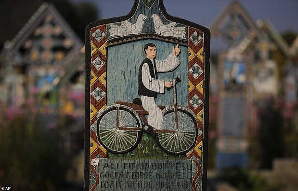 Des croix montrent des représentations des défunts et des nouvelles de leur vie et des circonstances de leur mort dans le cimetière joyeux
